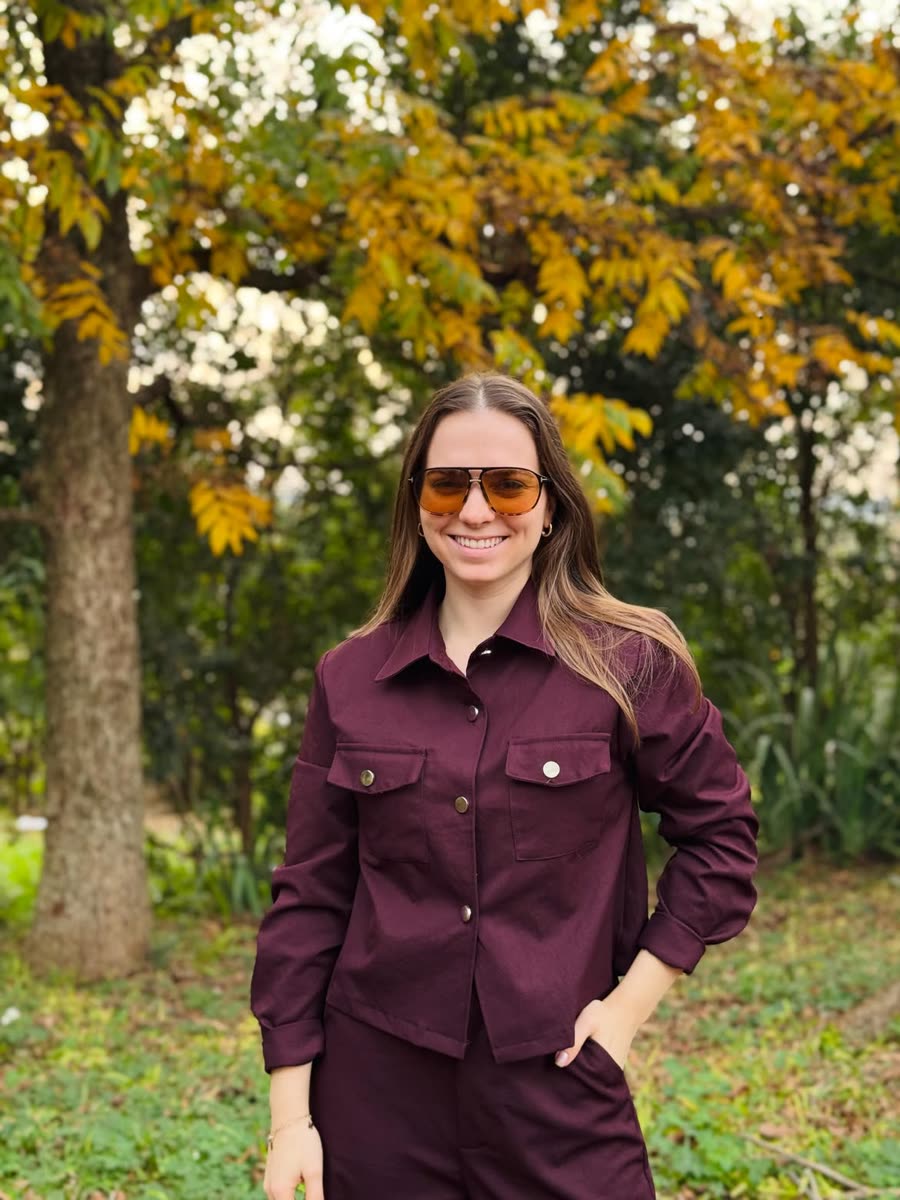 Aline Pieniz sorrindo ao ar livre no outono